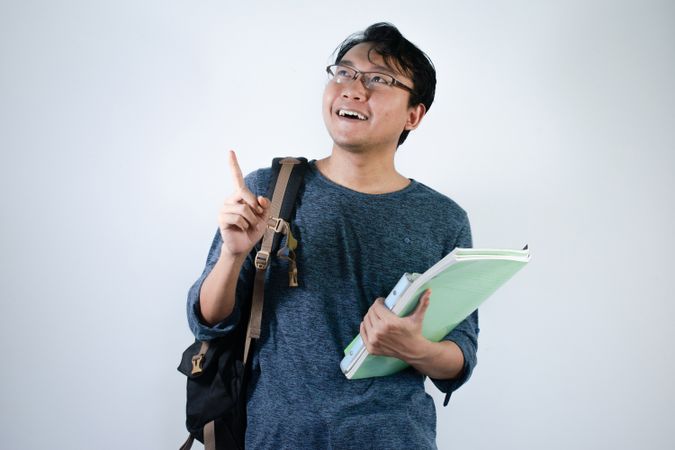 Asian young male reading book with thinking gesture