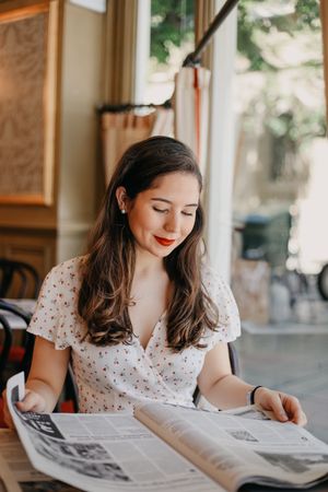Woman reading a newspaper in a vintage coffee shop