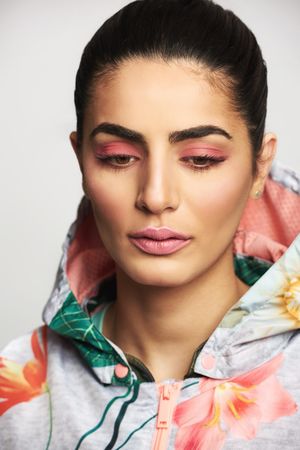 Beautiful woman pictured in colorful printed floral hoodie looking down