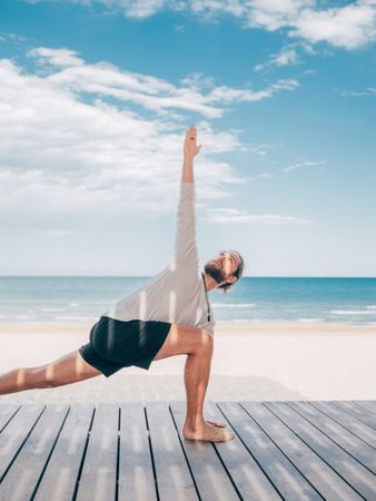 Man doing yoga by the beach
