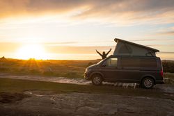 Man with opening hands standing on caravan