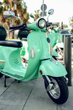 Green shiny scooter standing on parking