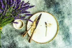 Top view of table setting with bunch of lavender and silverware