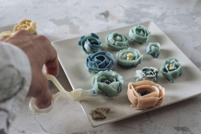 Hand holding buttercream flower
