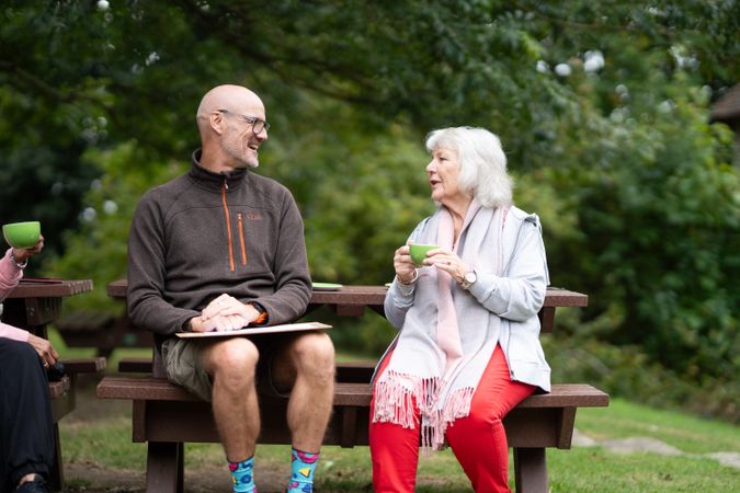 Mature woman sitting outside sipping tea with art teacher