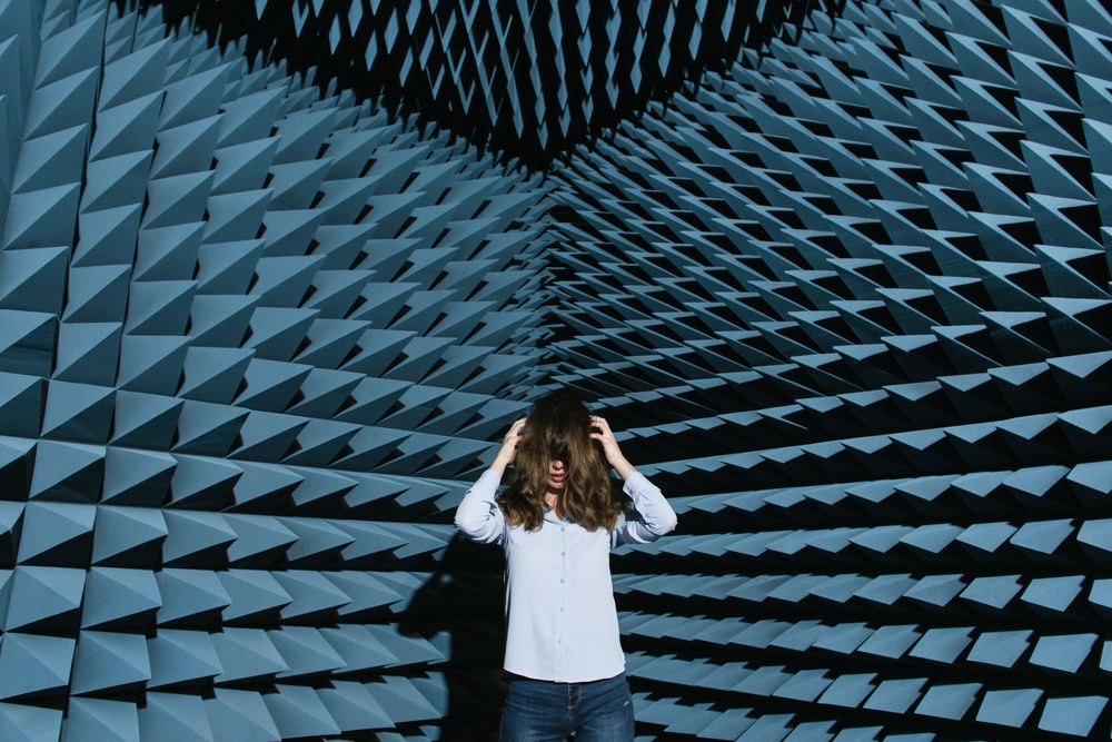 Woman in middle of sound room shaking head