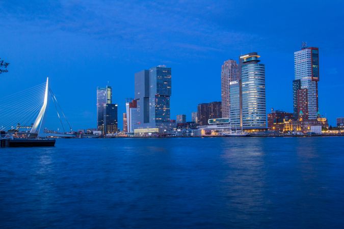 City skyline across body of water in the evening in Rotterdam, the Netherlands