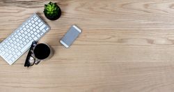 Wooden desktop with computer keyboard and coffee for a work or school setting