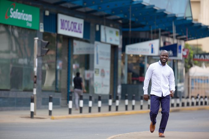 Man walking on road near shops