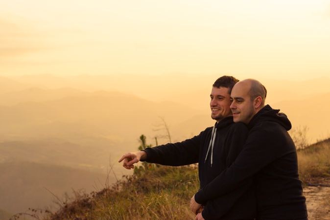Men hugging on road on hill