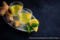 Two yellow detox drinks with ginger and lemon with copy space bDrlp5