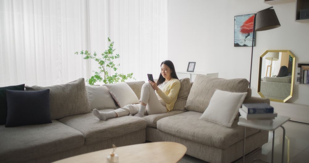 Young South Korean Woman Engaged and Connected Online, Enjoying Leisure Time with Her Smartphone