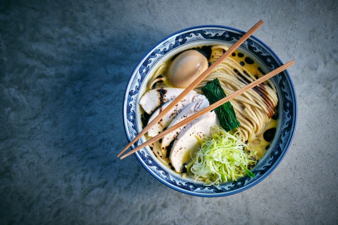 Tasty ramen with noodles and chicken fillet slices in bowl