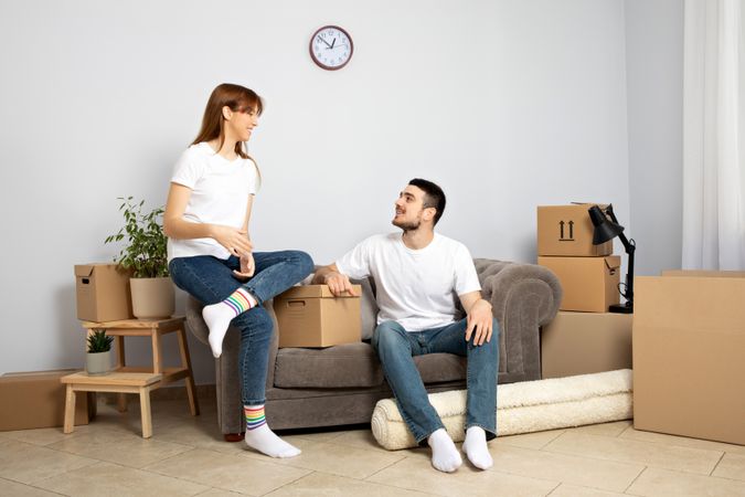 Moving concept, couple man and woman with boxes in apartment.