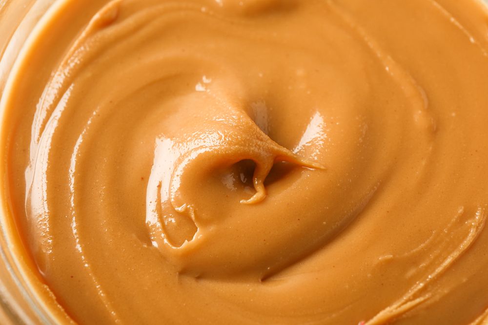 Peanut butter as background, space for text and closeup. A traditional product of American cuisine