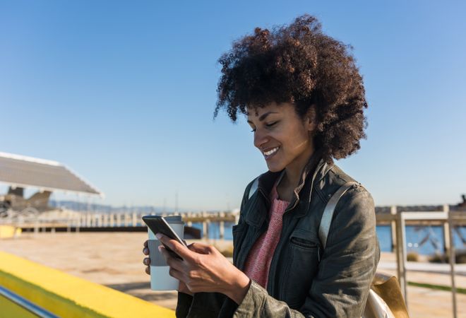 Black woman with afro hair leaning against brightly colored wall