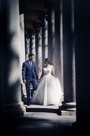 Newlyweds walking near columns