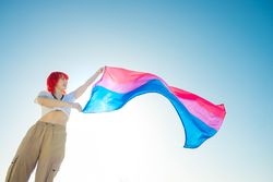 Woman with red hair waving a colorful flag