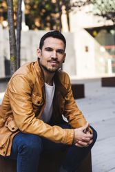 Stylish man sitting outside modern building