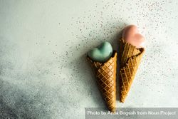 Two ceramic hearts in waffle cones on grey background with glitter and space for text beXXN6