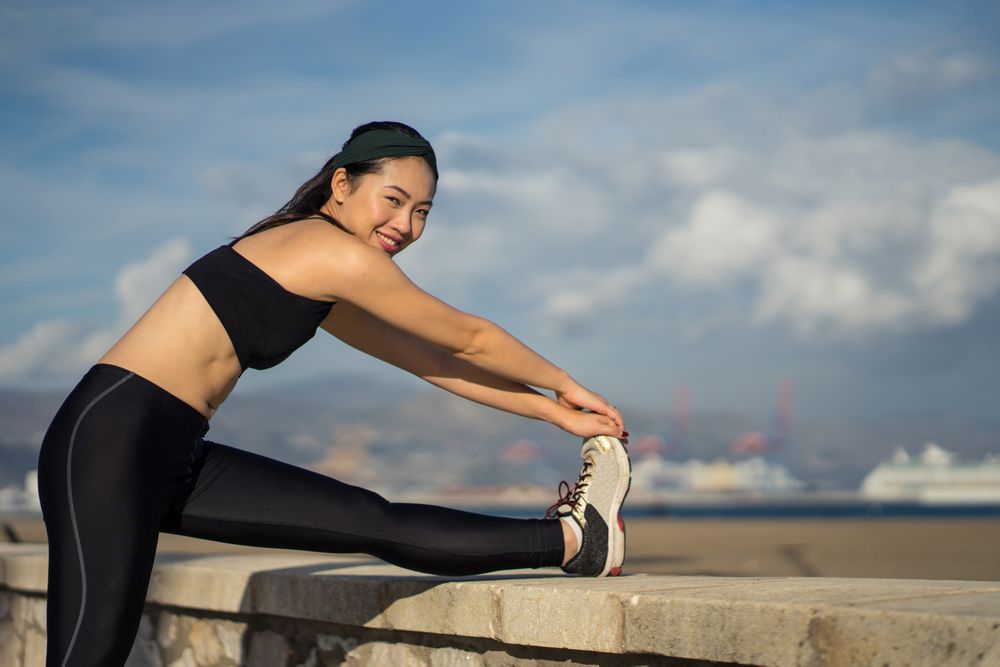 Woman stretching legs at seaside