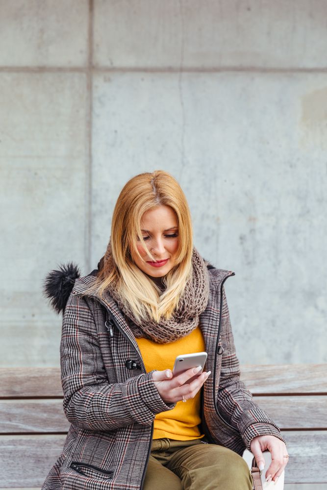 Portrait of blonde woman using her mobile phone