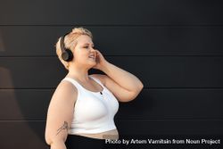 Smiling woman listening to headphones 0Pmer5