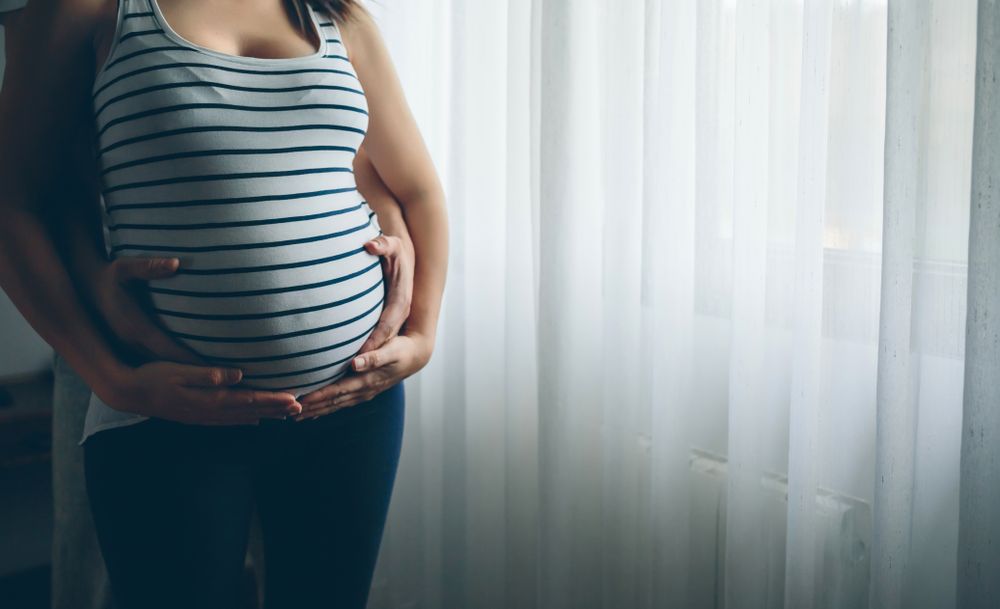 Pregnant woman embraced by her husband
