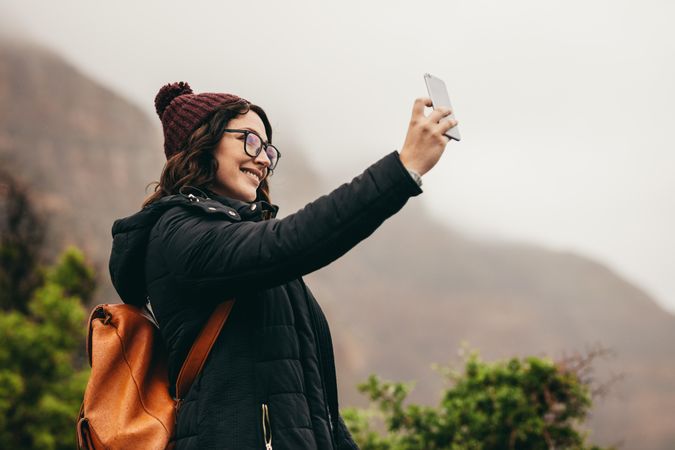 Woman taking selfie with smart phone on holiday