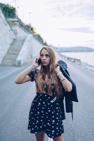 Long haired stylish woman speaking on smartphone