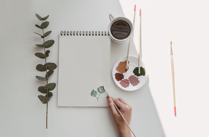 Person drawing flowers with watercolor