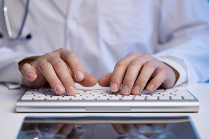Doctor Typing on Keyboard in Office