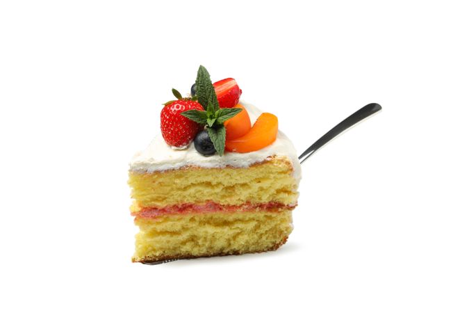 Shovel with berry cream cake isolated on plain background