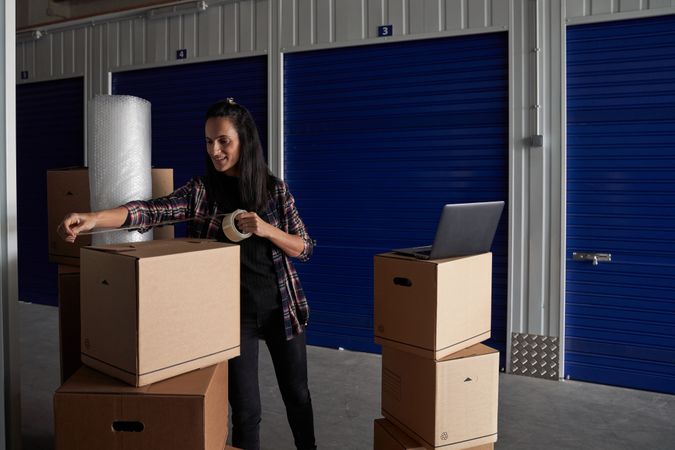 Woman packing box with scotch tape