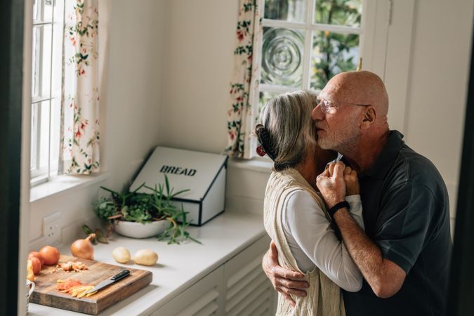 Older man and woman expressing their love for each other with a warm hug