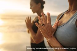 Close up of woman meditating at the beach with joined hands bG7NAb
