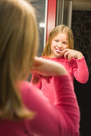 Cute girl brushing her teeth