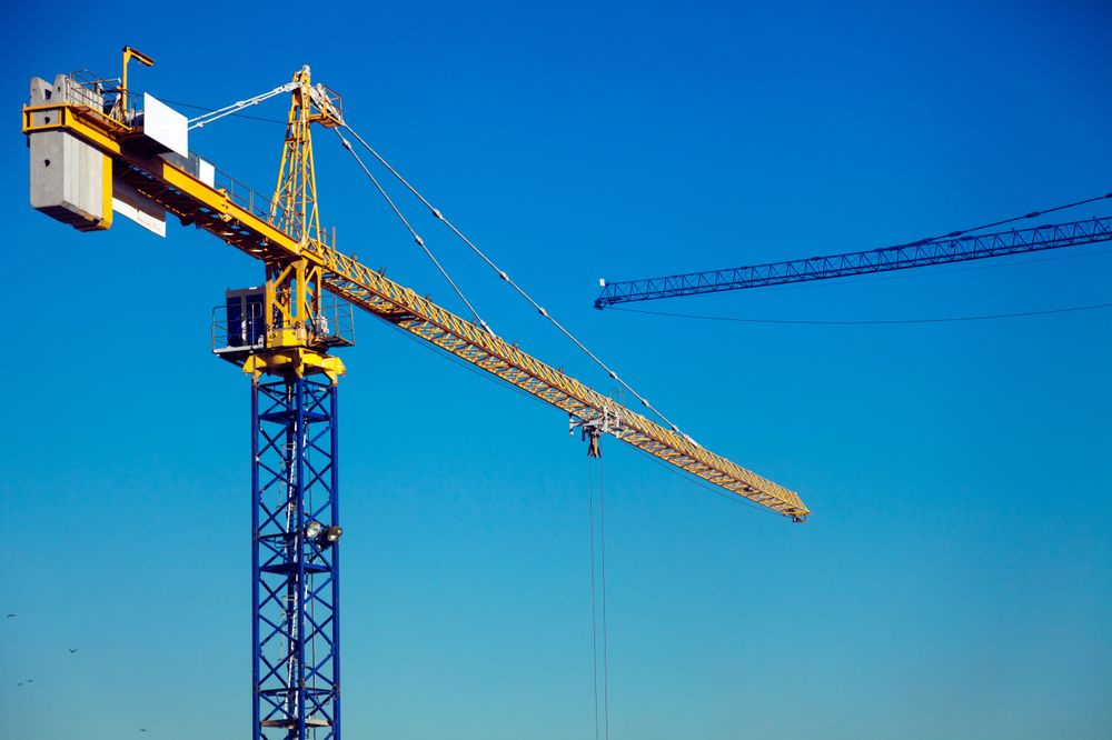 Tower Cranes Against Clear Blue Sky at Construction Site