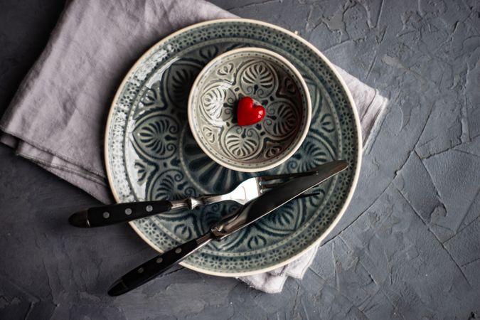 Dark patterned table setting with red heart decoration