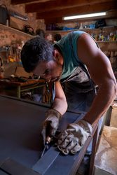 Man making marks on metal sheet in workshop
