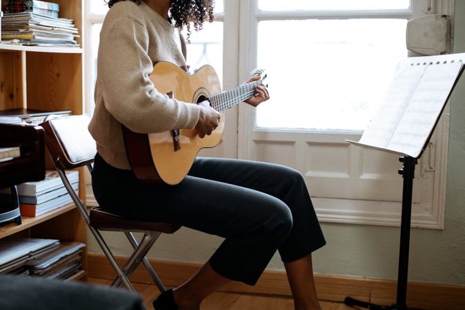 Woman playing guitar in studio
