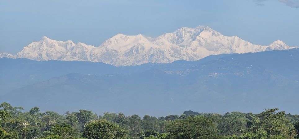 Majestic Snowy Mountains Behind Misty Hills