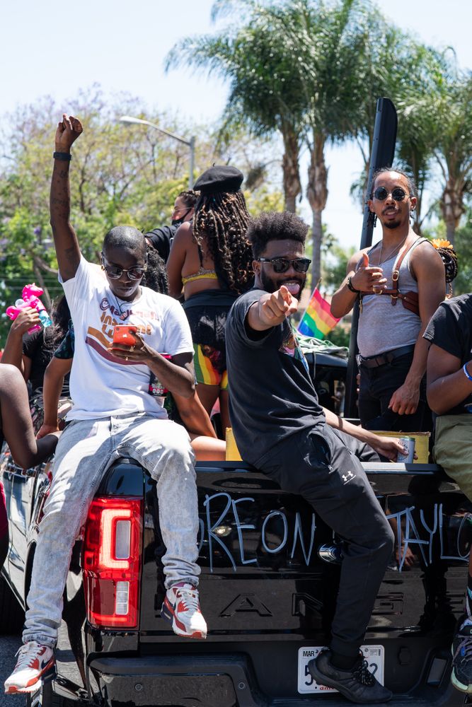 Los Angeles, CA, USA — June 14th, 2020: group of men riding in back of truck smiling at protest
