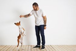Casual, tattooed man playing with his dog