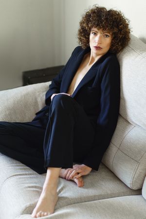 Woman in suit lounging on sofa