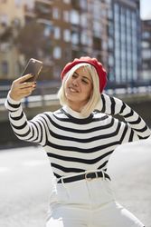 female in red beret taking selfie