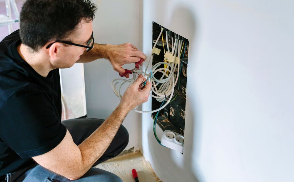 Technician cutting cable to install telecommunication box