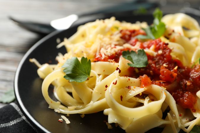 Composition with plate of tasty pasta on wooden background