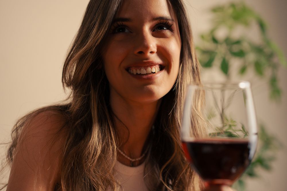 Young woman smiling wine glass lifestyle portrait relaxing home evening elegant drinking wellness balance