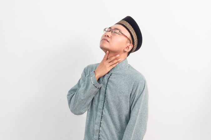 Asian Muslim man touching neck, thirsty gesture during fasting in Ramadan